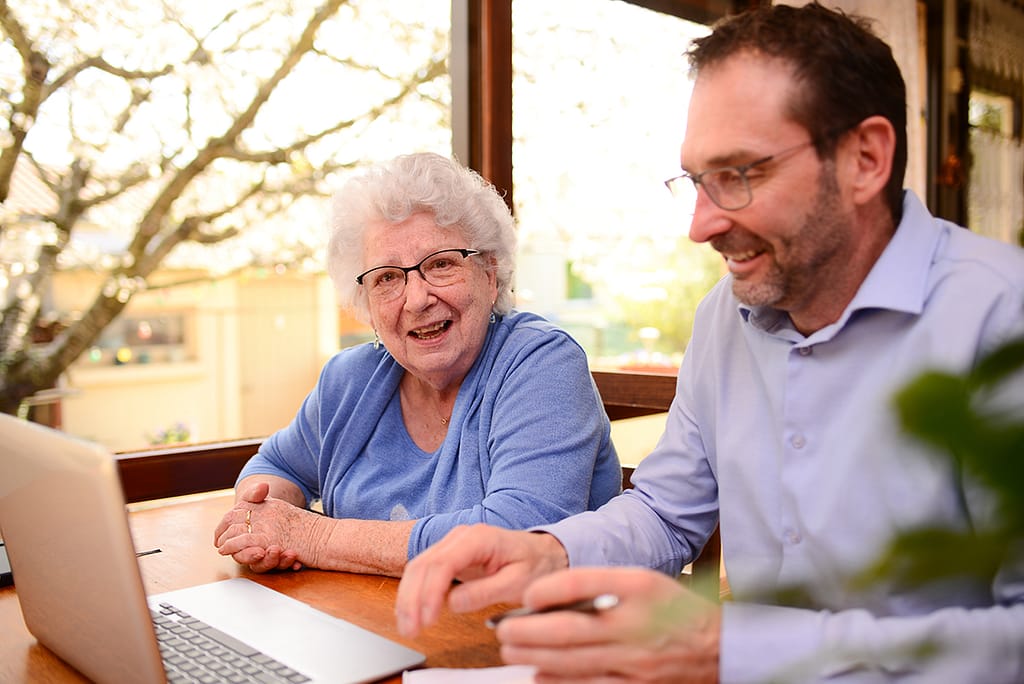 mature man helping elderly senior woman at home for paperwork and computer internet lesson mature man helping elderly senior woman at home with advanced estate planning